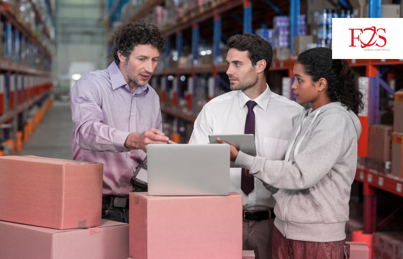 Three employee of carrier management team working on a laptop top of pink block